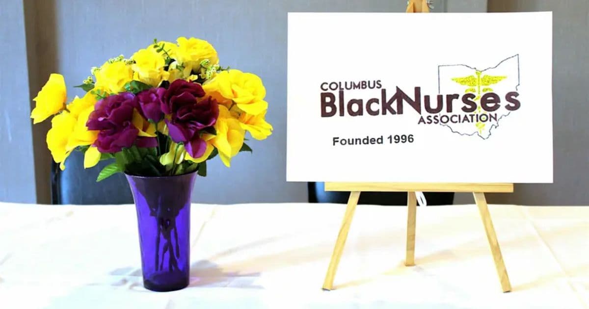 Columbus Black Nurses Association anniversary display with a floral arrangement and association sign on an easel
