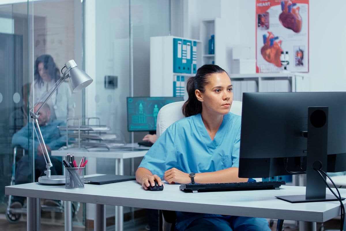 Nurse working at a computer in a clinical office